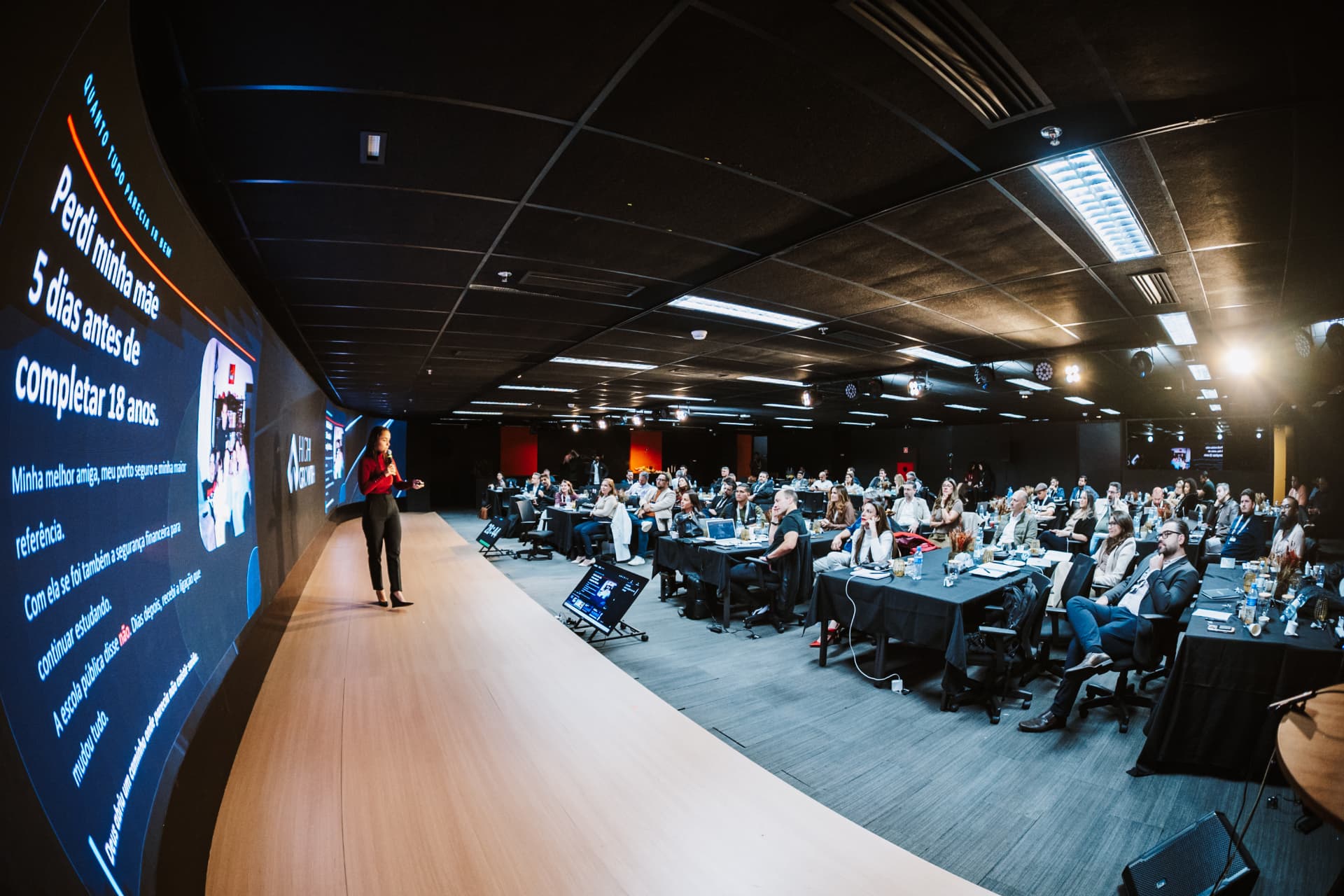 Auditório do Sales AI Experience com palestrante e executivos atentos